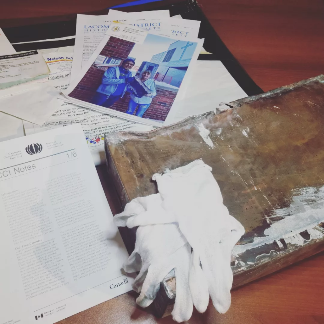 Time capsule with documents surrounding and archival gloves on top